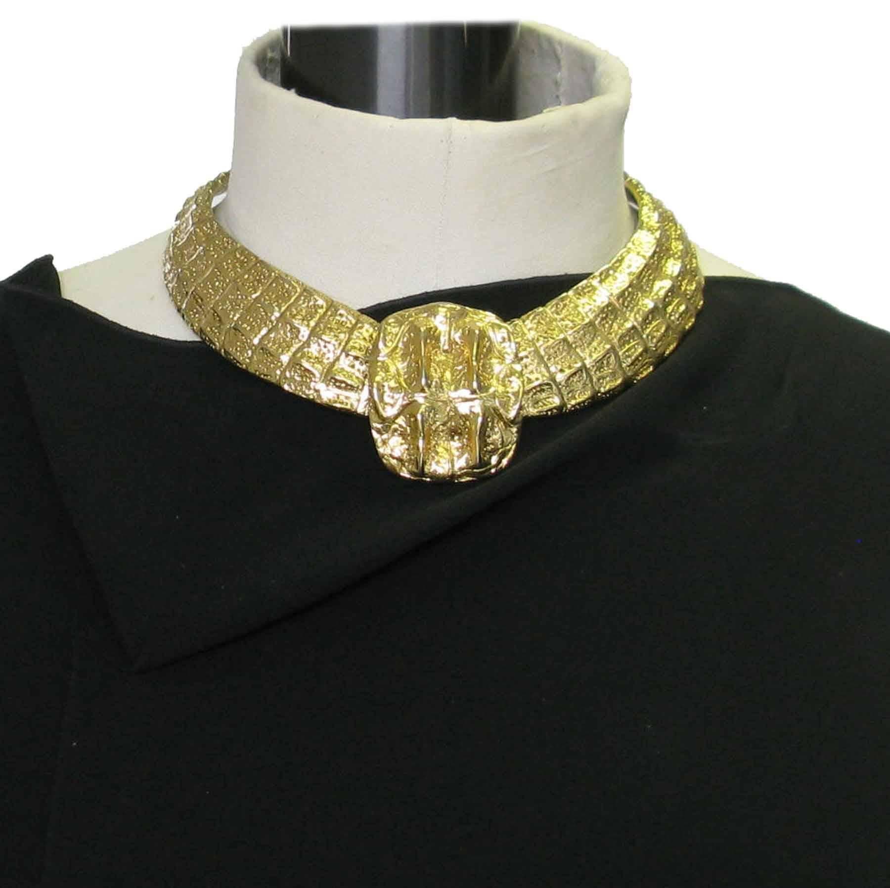 Stunning YSL YVES SAINT LAURENT choker necklace in gilded metal. The metal is worked to imitate the crocodile skin. Hook clasp. A small plate signed YSL ends the chain of the clasp.

Dimensions: at the shortest: 42 cm, the center piece measures: