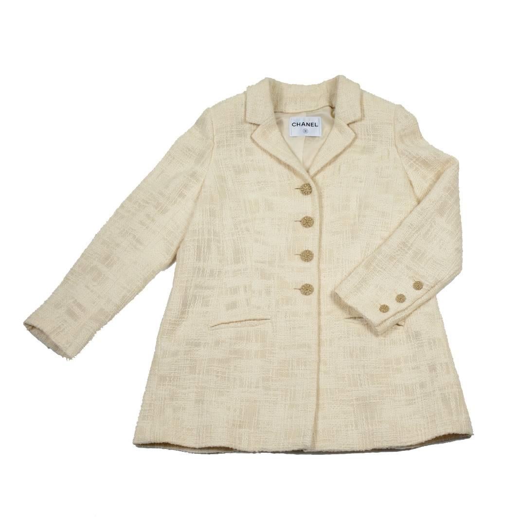 Beautiful Chanel long jacket from the 'Paris-Bombay' collection in ivory tweed. 
It is lined with monogram silk of the same color surrounded by a pale gold thread and closes with beautiful buttons. 
There are 3 welt pockets, a chest pocket and two