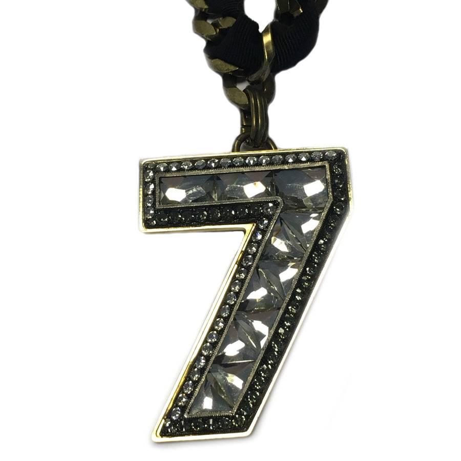 LANVIN necklace chain with large matte gold mesh surrounded by a black grosgrain ribbon. Pendant brooch number 7 in rhinestones. 

Dimensions: length: 64,5 cm - number 7: 4,9x6,5 cm

Delivered in a Valois Vintage Paris dustbag