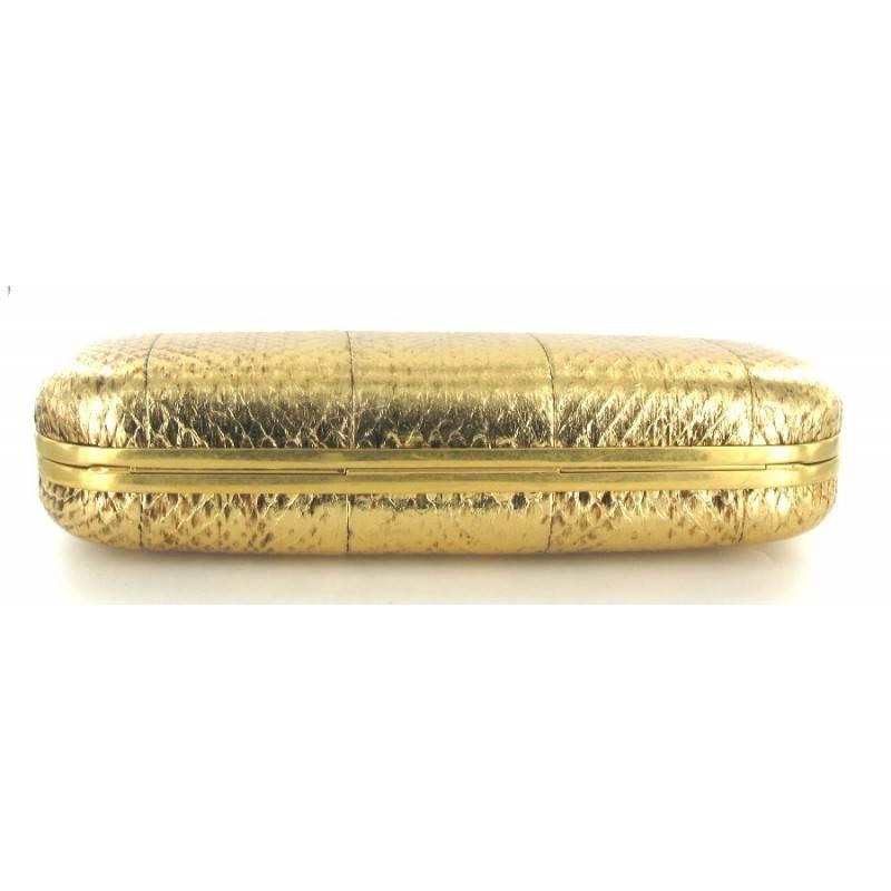 ALEXANDER McQUEEN clutch in gold python. Signature engraved 'Alexander McQueen'. This exceptional clutch is a rare model that will enhance your evening wear. 
It can be worn very elegantly, but also with a rock look. The rigid and structured design