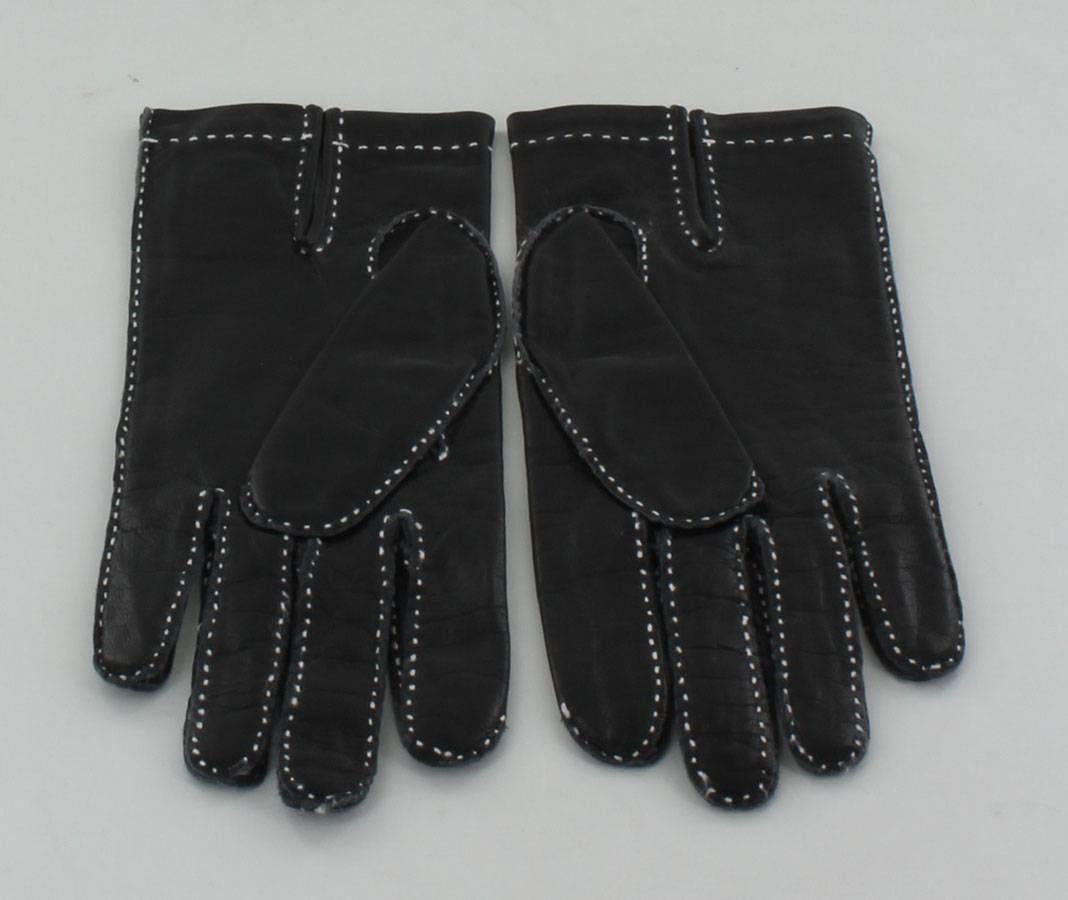 HERMES Handschuhe aus schwarzem Glattleder mit weißer Sattelnaht. Leichte Risse in der Handfläche der Hand.

Abmessungen: Breite: 8cm, Länge: 23cm