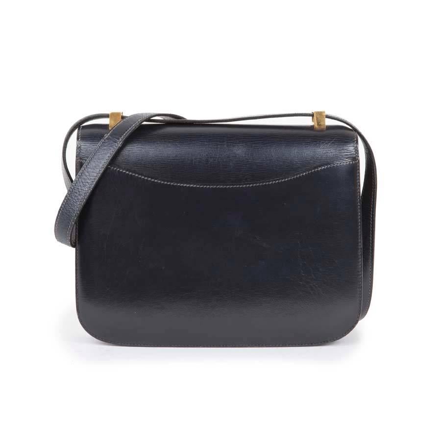 Vintage! Hermès Constance bag in navy box leather. Gilded hardware. The interior is in navy smooth lamb leather with two patch pockets, one zipped. 
Worn on shoulder with a shoulder strap of 78 cm.
No stamp, circa 1970.

Will be delivered in a