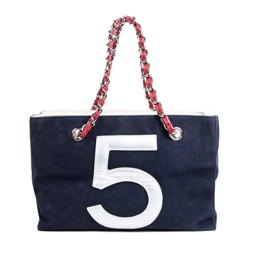 Collector! Chanel bag '5' in navy blue canvas and quilted silver leather. The 'CC' is in white leather and the number '5' in red leather. 
Two handles of 48 cm are in silver chain interlaced with red leather. 
The interior gives a metallic effect.
