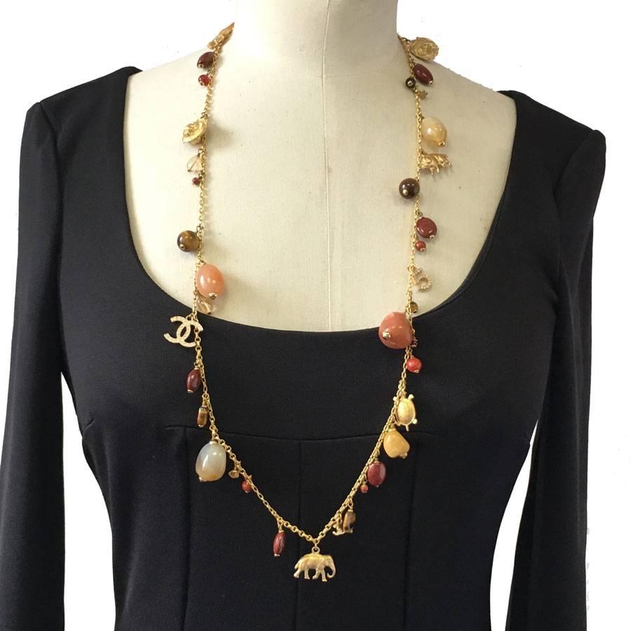 Exceptional piece! Superb Chanel couture chain necklace. Gilded metal chain, charms symbols of the house (5, CC, clovers, elephant, ...), semi-precious stones of multiple colors.
It can be wear also as a couture belt (see photo).

2001