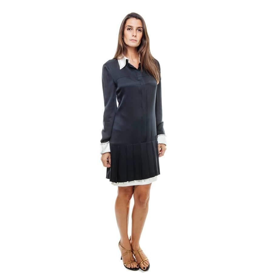 Very elegant silk CHANEL dress. Straight cut, it is adorned on the collar and cuffs of snap buttons. It closes with a row of invisible classic buttons.

Excellent condition. The white cuffs and collar are removable.

Fall 2003