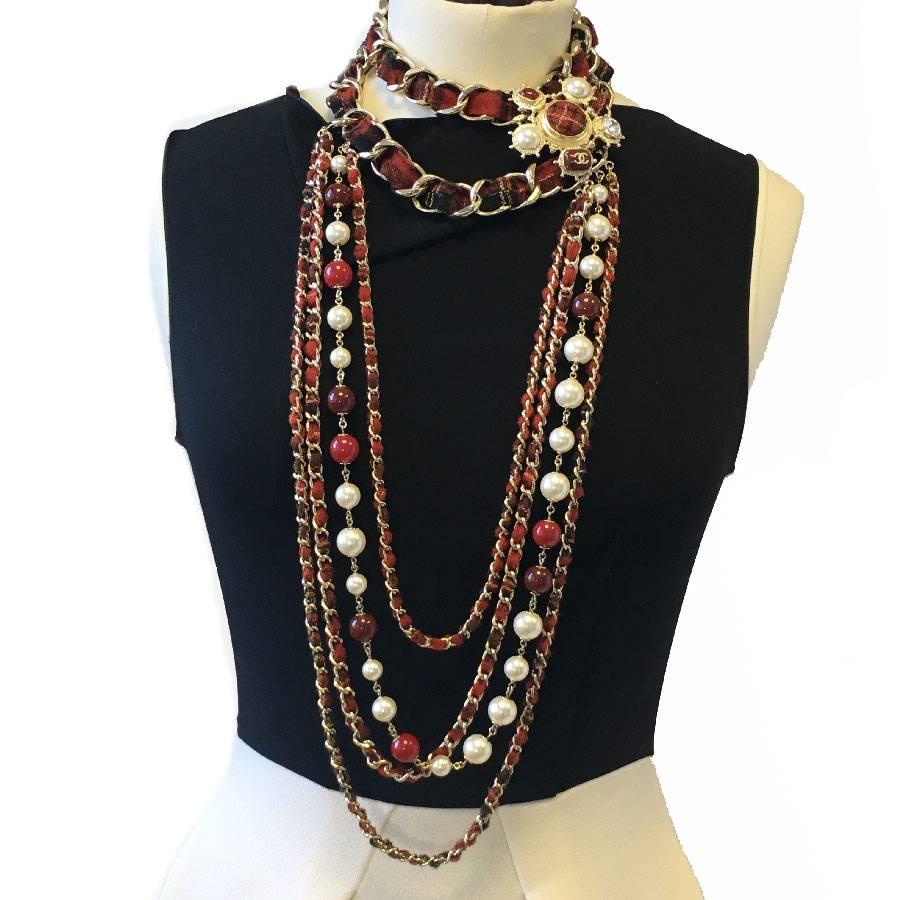 Beautiful Chanel necklace from 'Paris-Edinburgh' Métiers d'Arts 2013 collection.

Red tweed long necklace, row of pearly pearls and red molten glass, 4 gold metal chains interlaced with red tweed.

A beautiful jewel is on the left side. It is made