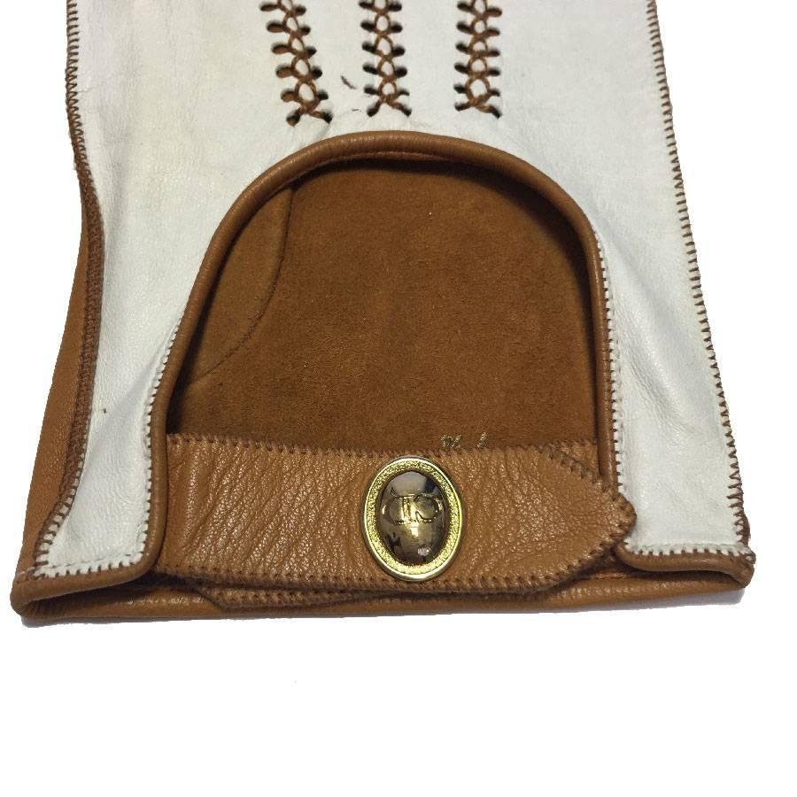 Christian Dior gloves in two-tone white land caramel amb leather. Size 7 3/4.

Beautiful caramel stitching on white leather. Caramel suede interior. The gloves are closed at the wrists by a golden snap.

Dimensions flat: wrist length to middle