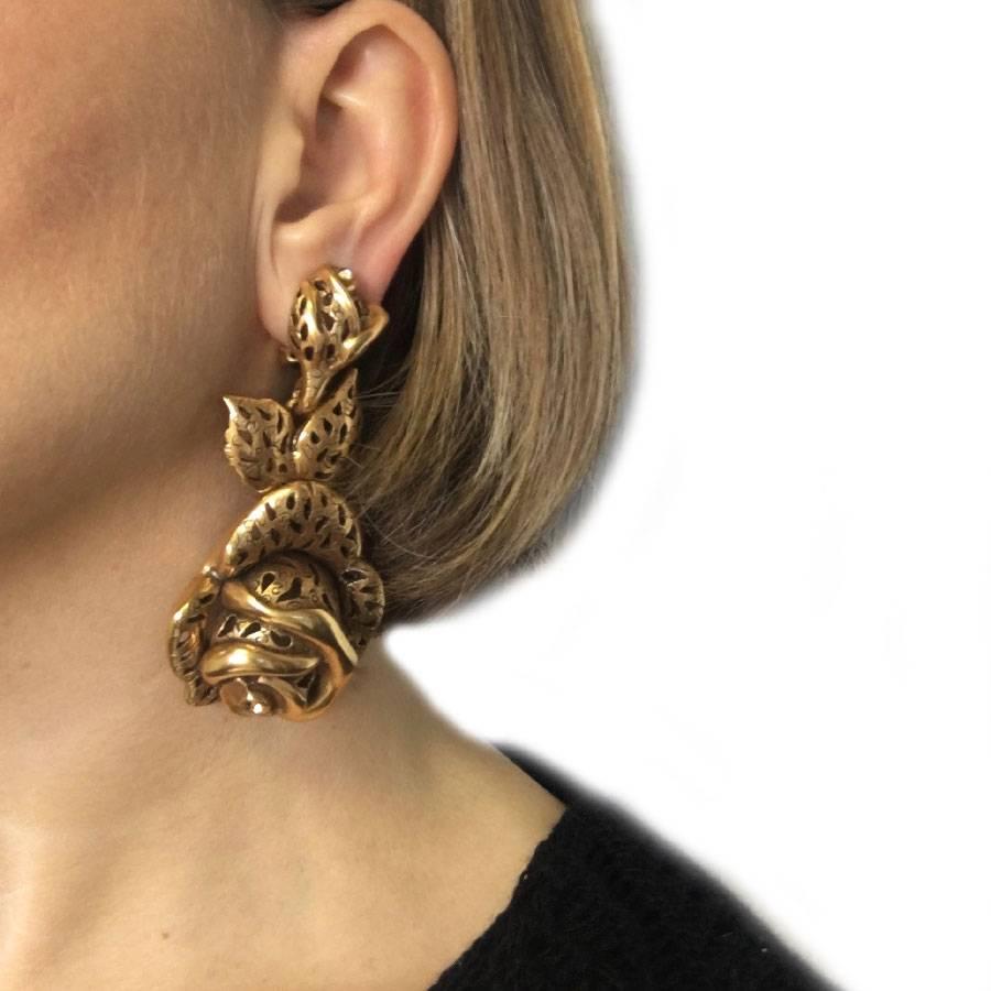 Oscar de la Renta pendant clip-on earrings rose in filigree gilded metal. Jewel set with 2 small yellow rhinestones.

Made in USA

Dimensions: length: 8.3 cm, bottom width: 4.1 cm

Will be delivered in a black non-original dustbag and box