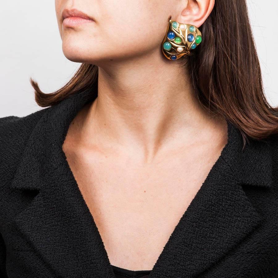 Givenchy Leaf-shaped clip-on earrings in gilded metal set with pearl beads and light sapphire blue and emerald green molten glass.

Dimensions: 4 x 5 cm.

Will be delivered in new, non-original dust bag