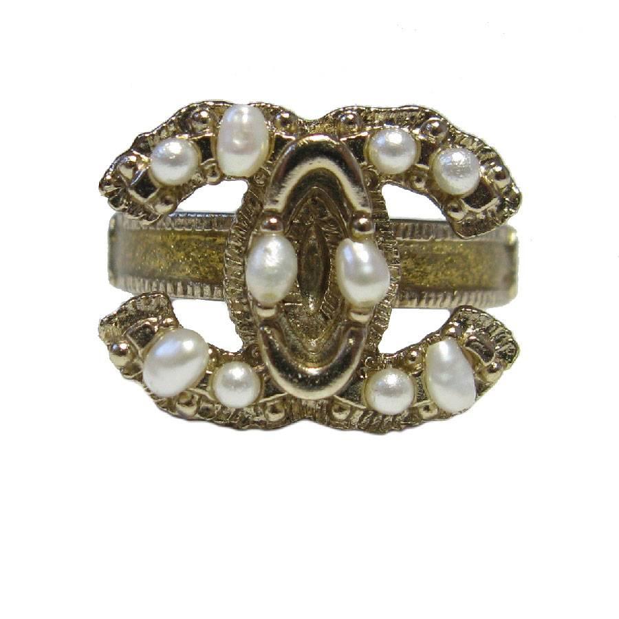 Chanel CC ring in gilded metal set with pearl beads. The outline of the ring is in gold glittered resin. Size 53FR

2011 cruise collection, made in France. 

Dimensions: inside diameter: 1.7 cm

Will be delivered in a black box (not Chanel), Chanel