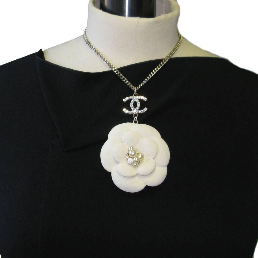 Splendid Chanel necklace, gold metal chain, white camellia pendant (sandblasted effect) set with pearly pearls, white and rhinestones. CC set with rhinestones.

Fall-Winter 2005 collection, made in France. Never worn.

Dimensions: total length: 45