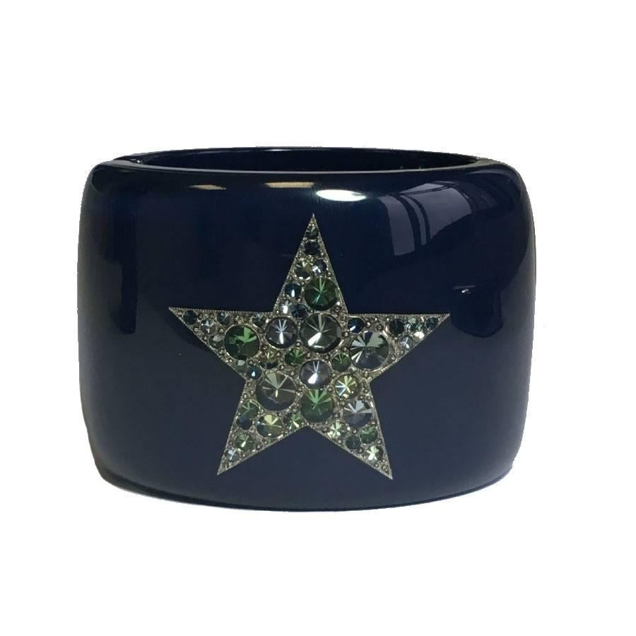 Beautiful Chanel cuff in blue lacquered resin. CC and star set with an inclusion of green, blue and white rhinestones.

Magnetic clasp and spring.

In excellent condition. Spring-summer 2012 collection. Made in France.

Dimensions: height: 6 cm,