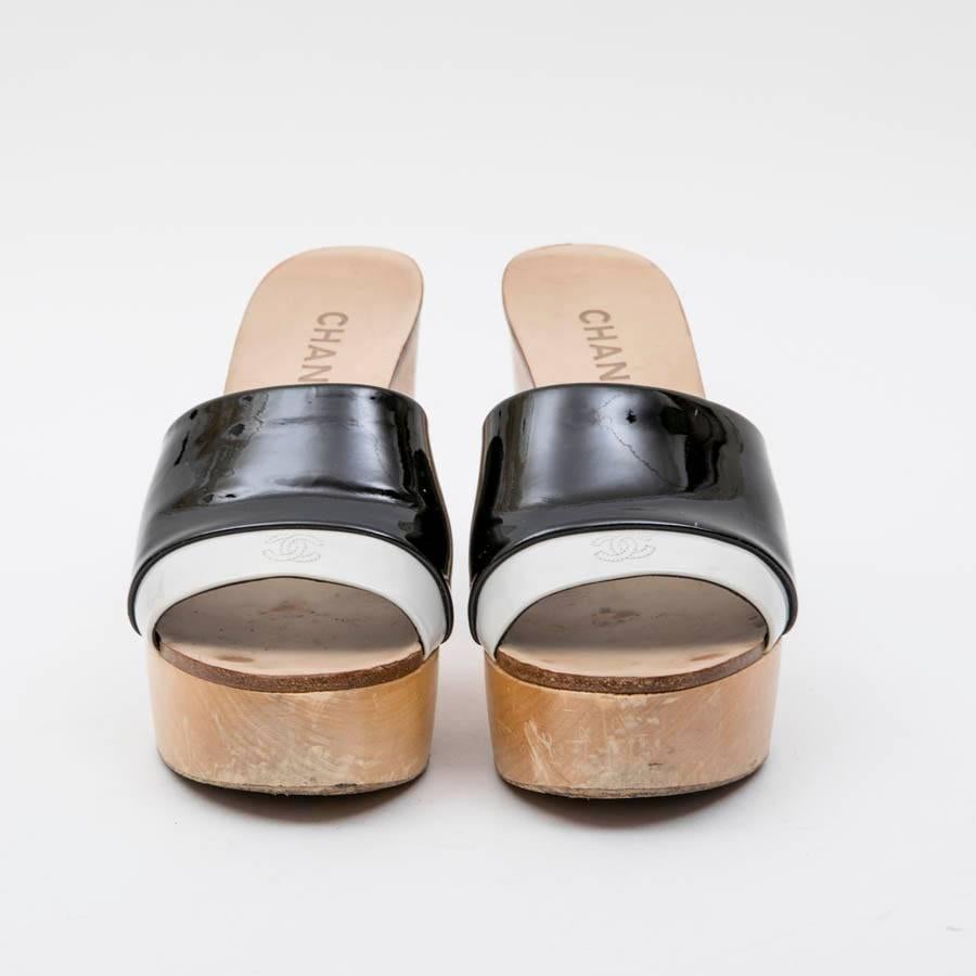 Chanel clogs mule in wood and black and light gray patent leather. Size 37.5.

Made in Italy.

In very good condition. Some wear marks on the front and back of the shoes. See photos.

Dimensions : Heel height 12 cm, platform height 3 cm, insole