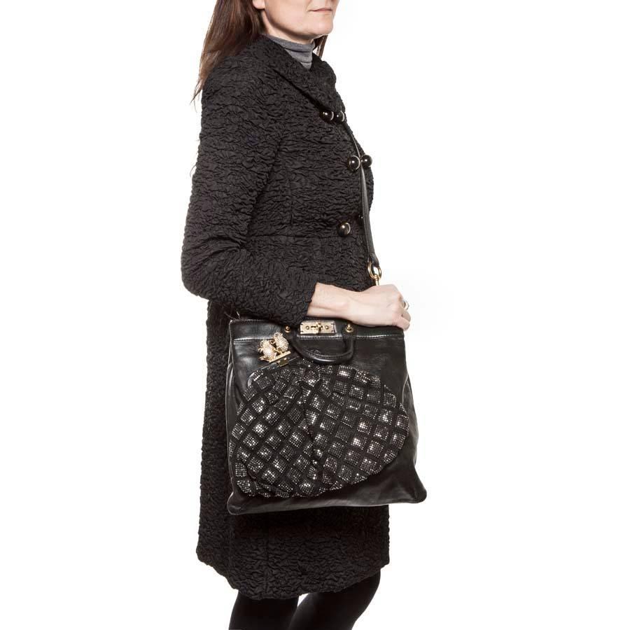 Superb Marc Jacobs bag in black smooth leather. In the front, there is a pocket inlaid with black crystal mesh as a large wallet, topped with 2 golden frogs set with brilliants.

Worn by hand by 2 small wrists or shoulder or crossover thanks to a