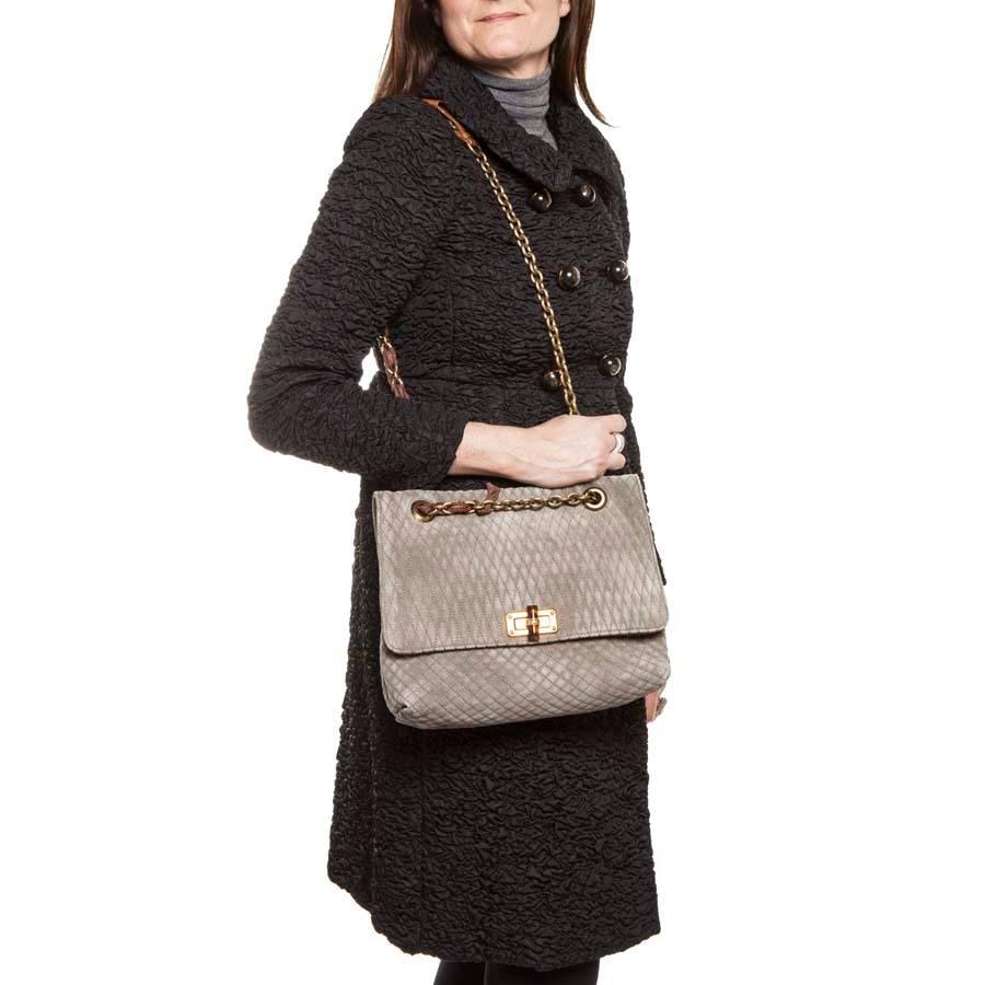 Lanvin bag in gray mouse quilted suede, aged gold chain shoulder strap. Brown grosgrain ribbon, brown leather patch, and Lanvin medallion charm.

Worn on the shoulder, adjustable cross-over. This bag was cleaned at the renowned dyer Germaine Lesèche