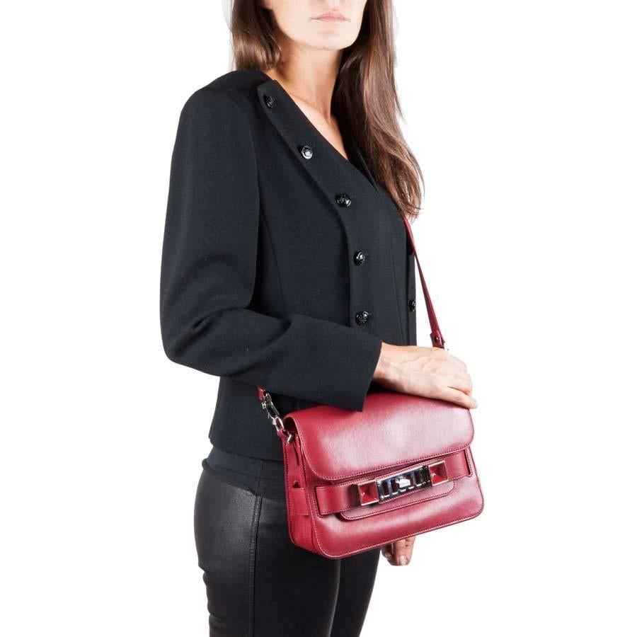 Proenza Schouler double flap bag, PS11, in burgundy smooth leather. Silver metal hardware. Snap closure. The interior is in canvas with a zipped pocket. A 2nd pocket under the second flap and another zipper at the back.

Worn on the shoulder or