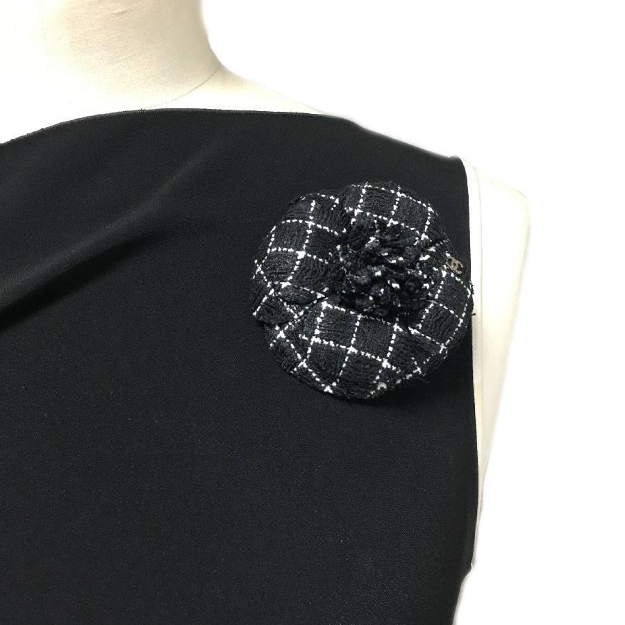 Chanel camellia brooch in black checkered with white fabric, a silver CC is affixed to the front of the brooch. 

Perfect condition. The brand pellet is missing from the back.

Dimensions: 8 x 8 cm

Will be delivered in a black box (no Chanel),