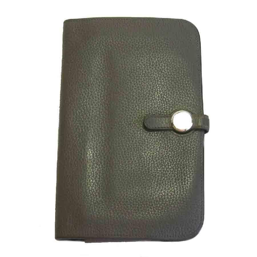 Hermès Dogon Duo wallet in étoupe togo leather. Saddle nail clasp in silver metal. It has a removable zipped wallet.

Inside: 5 credit card slots, 2 billfold gussets.

In good condition. The leather is weathered. Traces of use inside the wallet (see