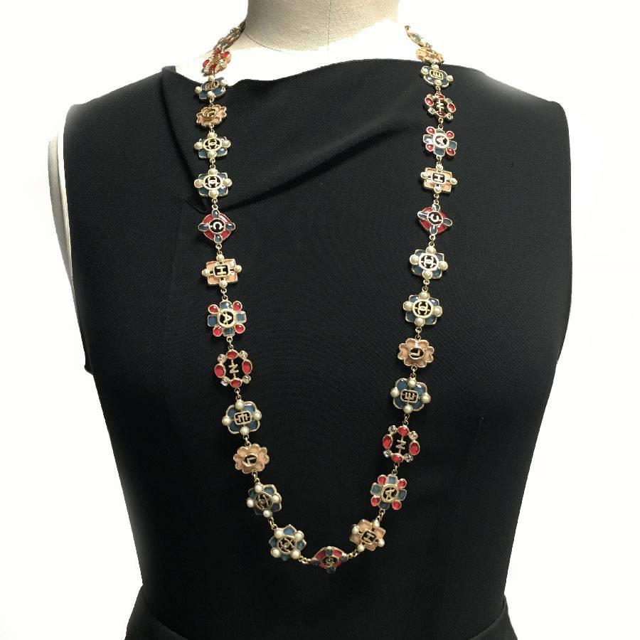 Chanel long necklace in gold metal and blue, pink, fuchsia molten glass, rhinestones and pearls. Inscription CHANEL and CC on each piece of the jewel. 

Impeccable condition except for some lack of pearly pearls (almost invisible).

You can wear it