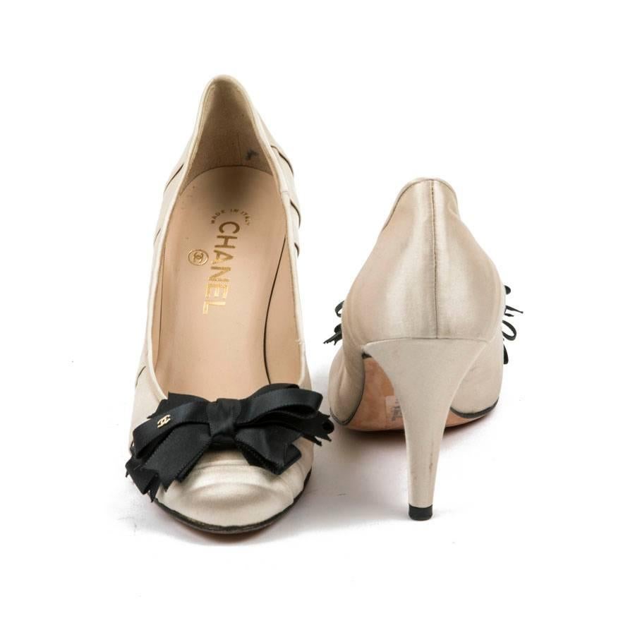 Chanel pumps in beige and black duchess satin. Black satin bow with golden 