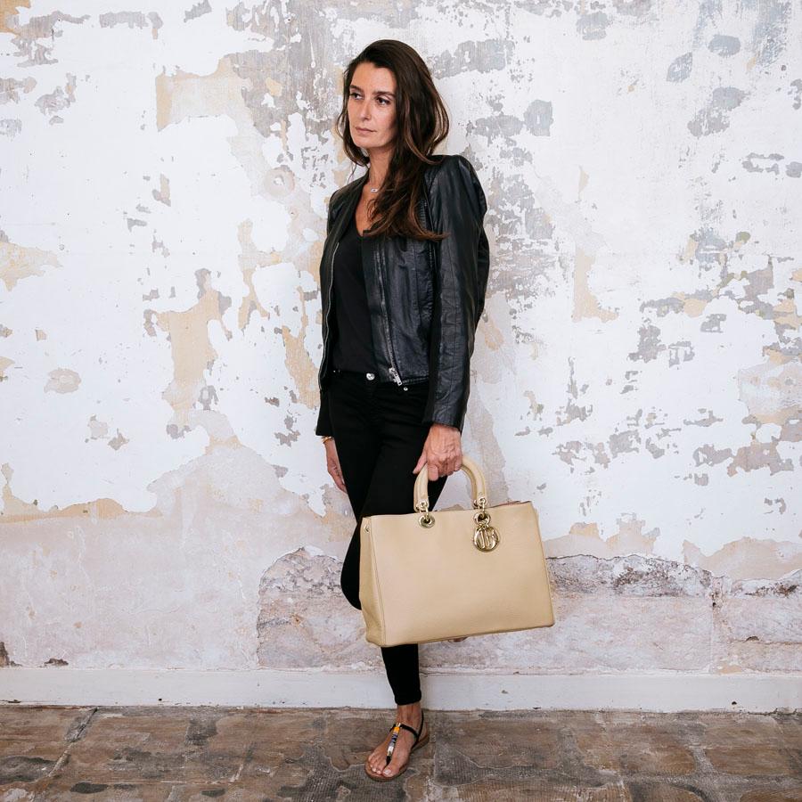 Christian Dior 'Diorissimo' bag in nude beige taurillon leather. Gilded metal hardware. The interior is in pink leather and has two flat pockets. Snap closure. 
Clutch with zipper inside. Snap buttons on the sides of the bag.

Worn by hand or