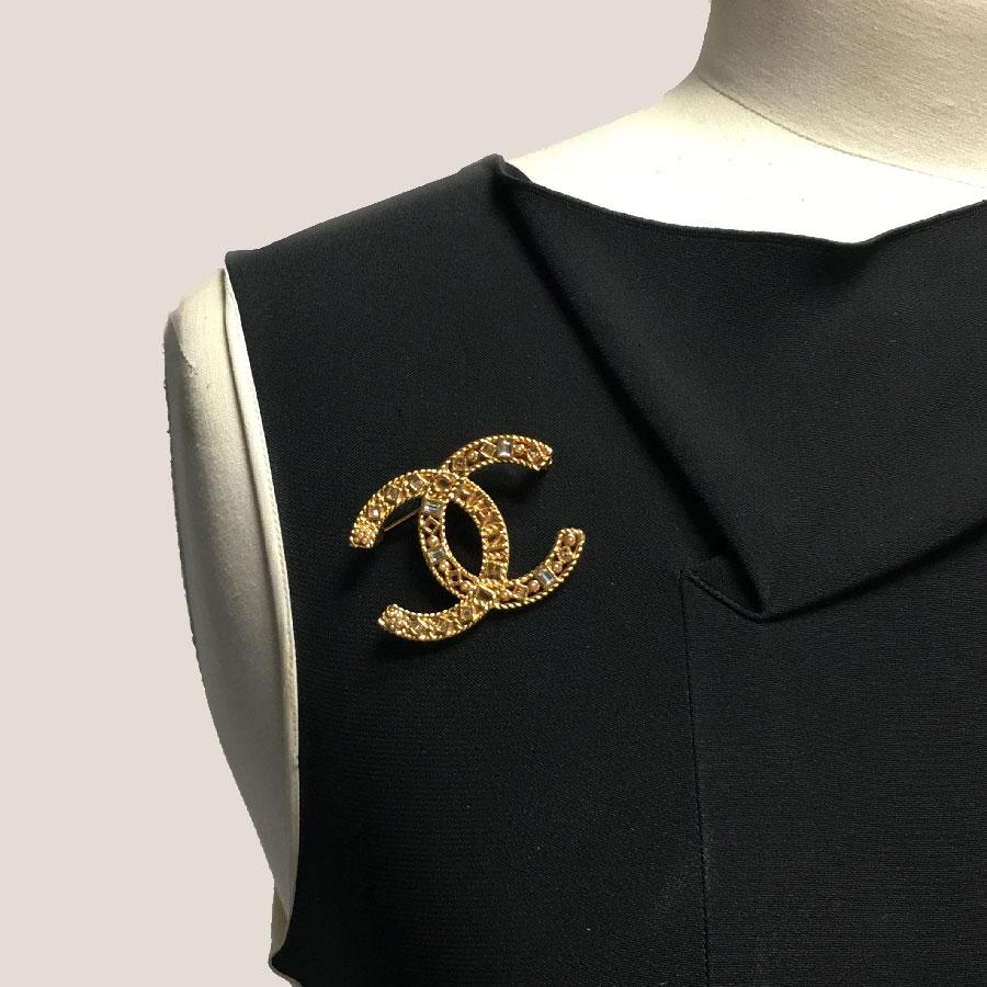 Chanel CC brooch in openwork gold metal, rhinestones, shiny and small pearly pearls.

Immaculate condition.

Made in France, spring 2010 collection

Dimensions: 4.7x3.5 cm

Will be delivered in a new, non-original dust bag