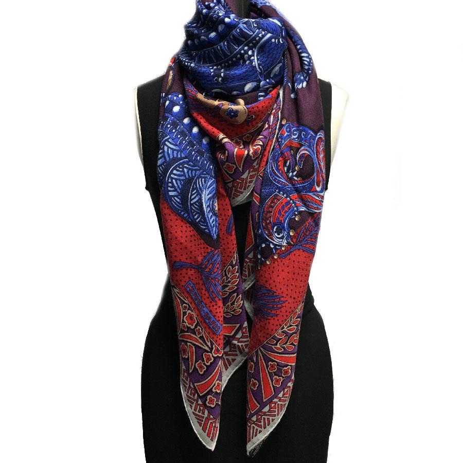 Superb Hermes shawl, model 'Zenobie, Reine de Palmyre' in aubergine, blue and red tones.

Mint condition. Stamp X of private sales under the label

Composition: 70% cashmere and 30% silk.

Dimensions : 140x140 cm

Will be delivered in a new,