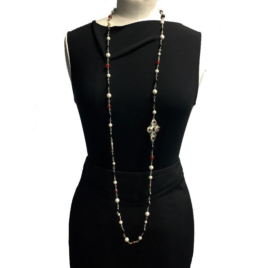 Beautiful Chanel gold metal necklace with pearls of color: pearly, black and amber. Gilt metal cross set with amber color beads and a CC.

Immaculate condition. Collection 2013. Can be worn in single or double rank.

Dimensions: overall length: 139