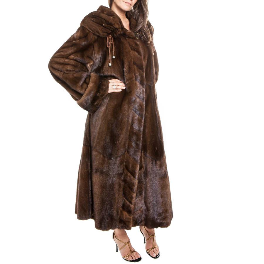 Rebecca long coat in brown mink. 

No size tag equals a size 40 FR. Monogram silk lining. 

Wide collar that covers the shoulders tightened by a link. At the end of each link a clochette, (1 missing). 
A slit on each side of the coat. Closing with a