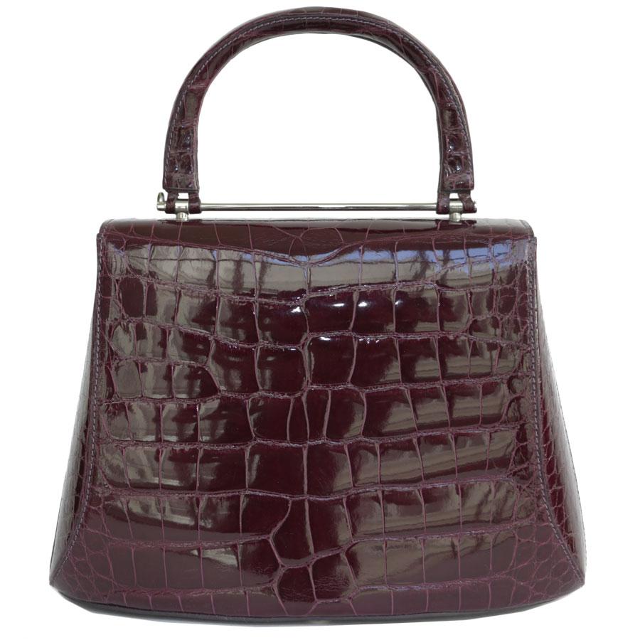 ASPREY OF LONDON burgundy crocodile bag. The ultimate! 
The hardware is in palladium silver metal. The interior is in dark purple smooth lambskin (state of use), with 4 patch pockets including 1 zipped.

It's a bag in excellent condition.
Dimensions