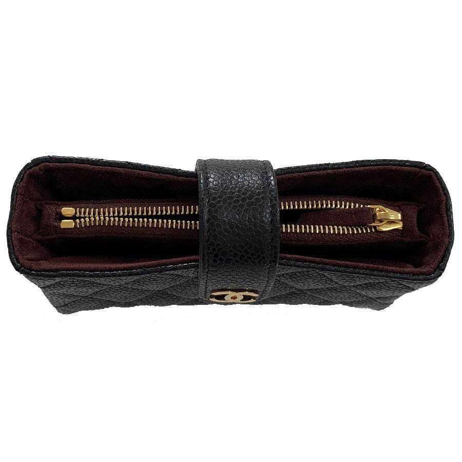 Small quilted CHANEL pouch in black caviar leather with a CHANEL gilt metal clasp. It includes: two paper compartments, a zipped pocket. 
Closing the pouch with a snap. Its inner lining is burgundy suede.
It can be used for papers, credit cards or