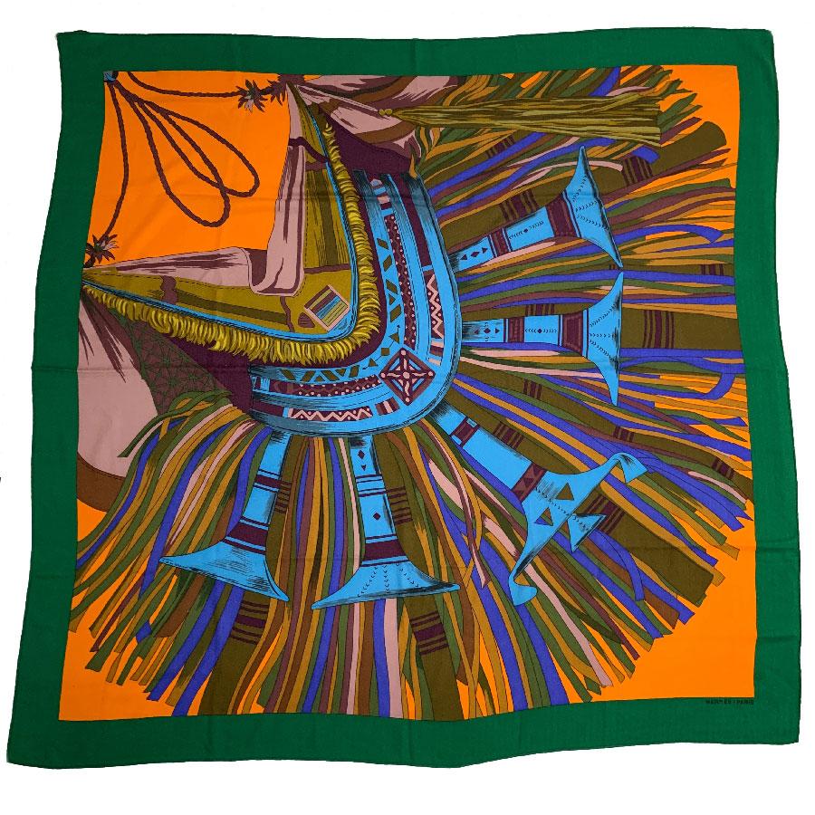 Very beautiful HERMES shawl, model 'Cuirs du Désert'. It is cashmere and silk whose dominant colors are green, orange and blue. It was designed by Françoise De La Perrière. It is a French manufacture.

Shawl in very good condition. A small hole