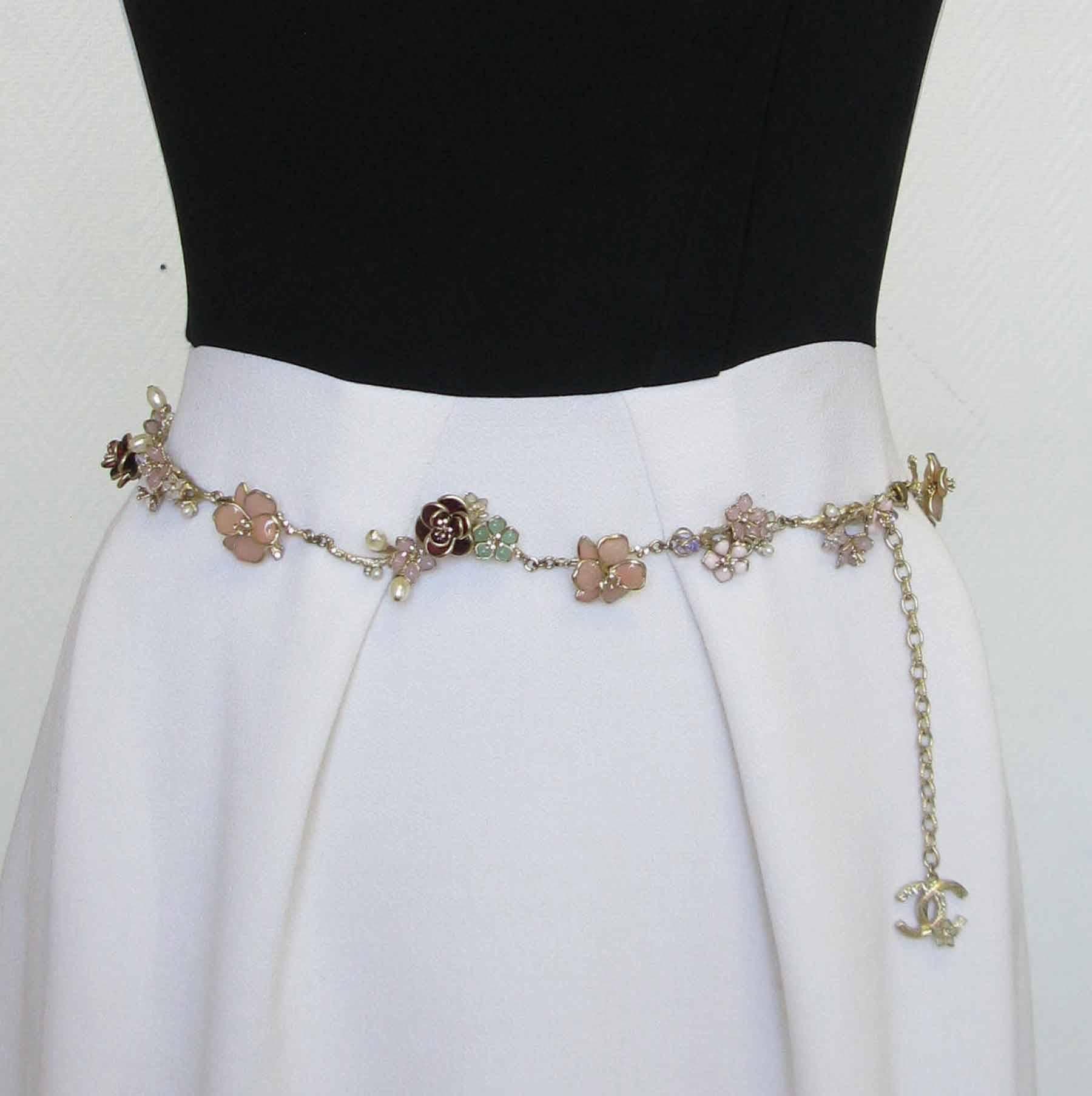 Sublime belt-necklace Chanel stitching in gilded metal pale gold color, flower petals in molten glass of various colors: pink, burgundy, green, mauve. Pearls oval and shiny. 
A beautiful CC set with brilliants and a small flower completes the chain