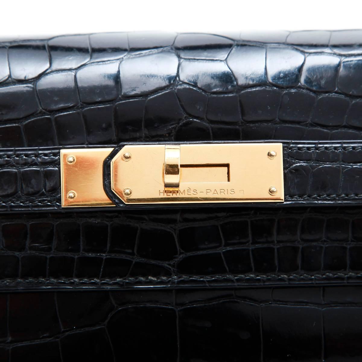 Vintage! Hermes 'Kelly' size 32 bag in black crocodile porosus leather.

Included : keys, padlock, tirette and clochette.

Stamp G in a circle (1977). Hardware in gilded metal.

The interior is in black smooth leather with 3 patch pockets including