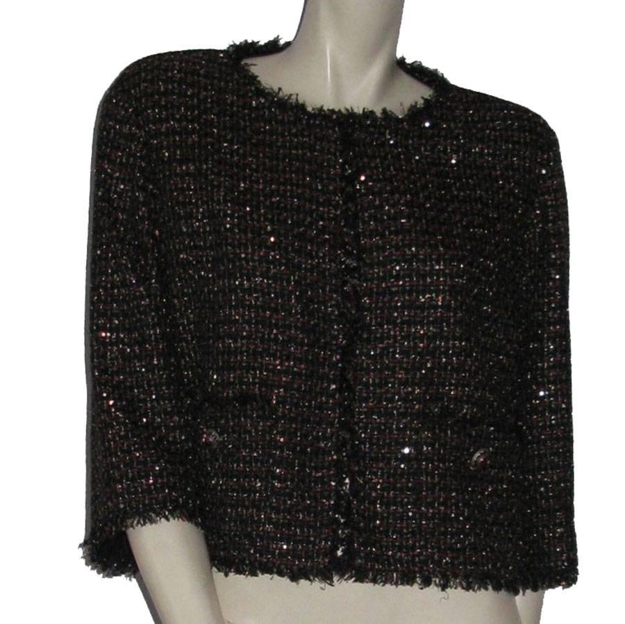 Small short jacket Chanel in bicolor blue navy / bordeaux tweed embroidered with golden glitter. Straight cut, shoulder pads, crew neck, 'unfinished' effect at collar, wrist, closure band and bottom. 
Closed with 4 small black hooks very discreet. 2