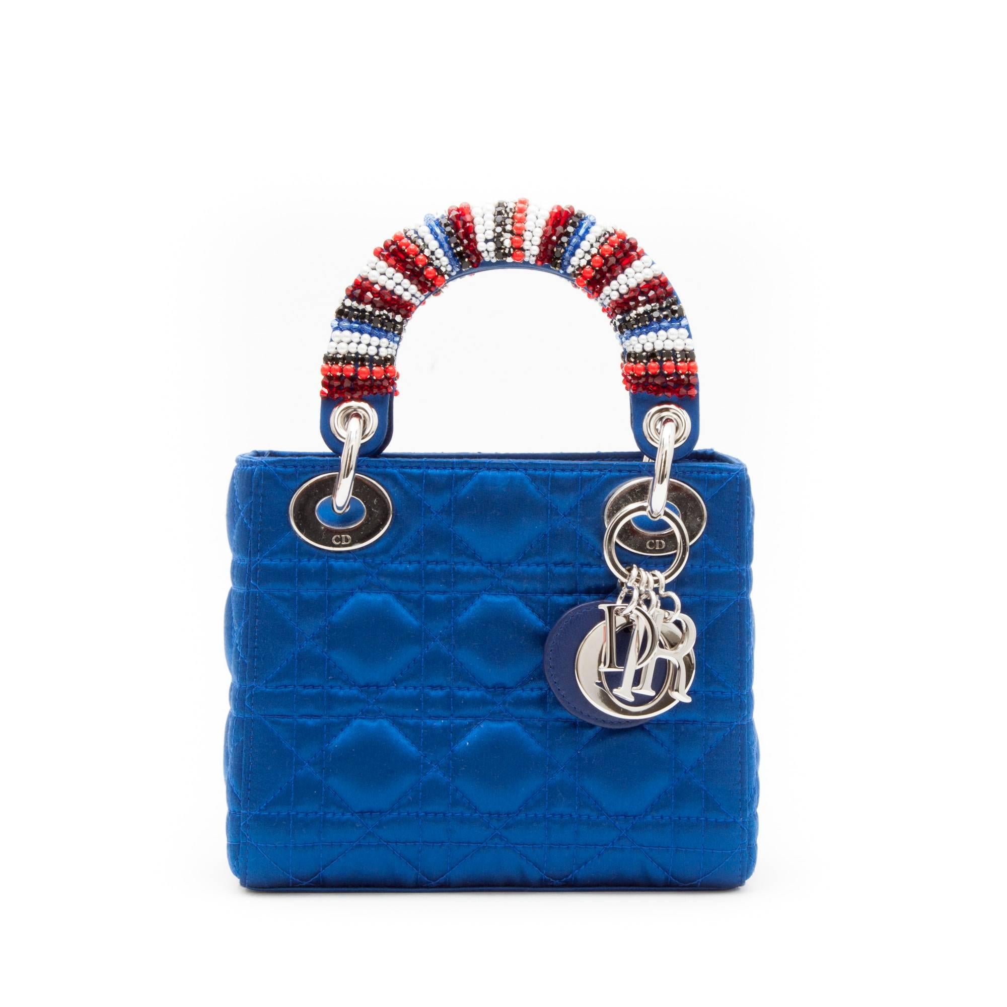 Christian Dior Lady Dior bag in electric blue silk satin, silver D.I.O.R block charms. Pearls and rhinestones set on the handles.

Worn on shoulder with a removable shoulder strap of 110 cm.

Height of the small handle: 9 cm.

Will be delivered in