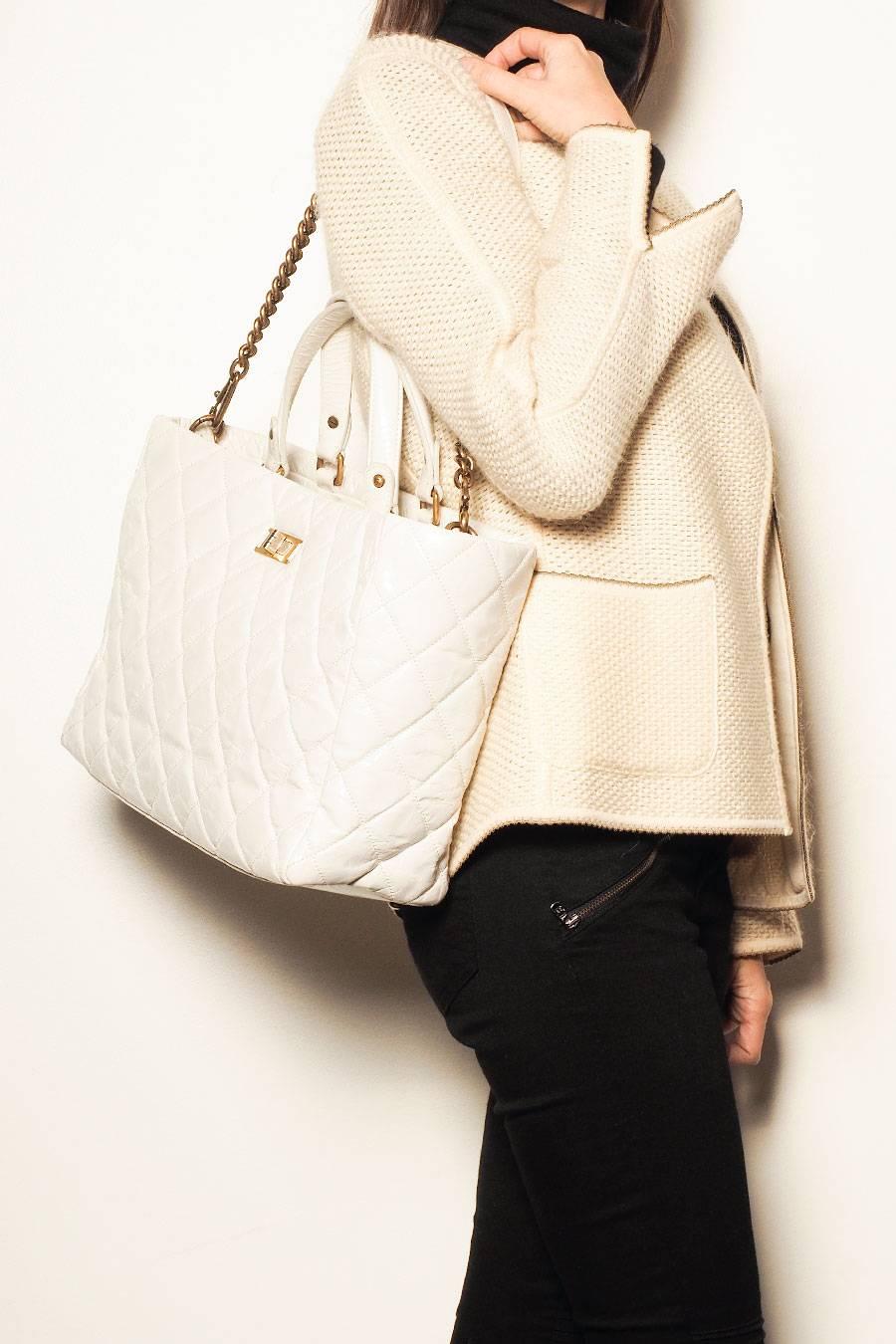 Chanel tote bag in aged white patent leather. Clasp 2.55 two-tone gold and silver. 

Included : Hologram: 1575 ...(year 2011)  and its authenticity card. 
The interior is in beige fabric. Hand carried with two handles and on the shoulder with a