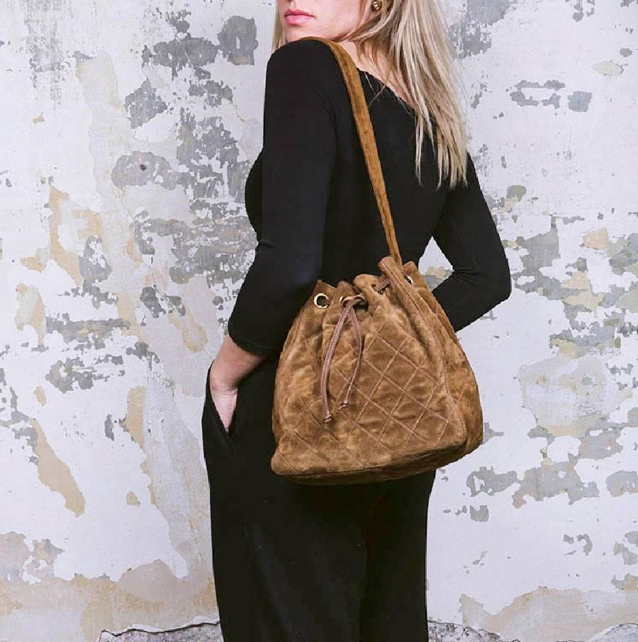 Chanel vintage bucket bag in brown suede. Gilded metal hardware. Chanel logo on the shoulder strap.

Dimensions: Length 26cm, height 25cm, depth 11.5cm. Length of the shoulder strap 72cm.

Will be delivered in a new, non-original dust bag