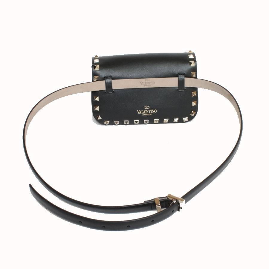 Lovely Valentino Rockstud line clutch in black leather and gilded studs.

Worn by hand or on the waist with the supplied belt.

The interior is lined in black cloth. Hologram TVJWD8084 .....

Dimensions: Height: 10 cm, length: 16.5 cm, depth: 6 cm,