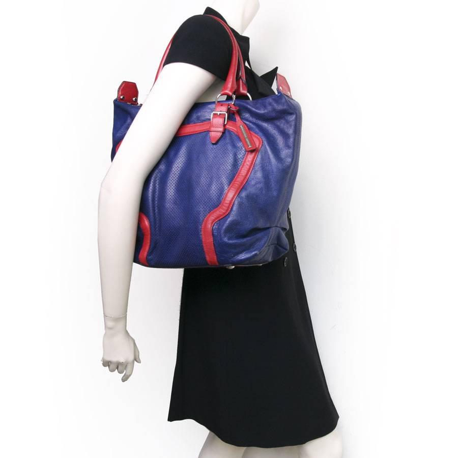 Alexander Mc Queen Very original bag in red and electric blue. grained and perforated lamb leather,  Zip closure in silver metal. The interior is blue canvas with a large zipped pocket. 
Worn on the shoulder or arm with two handles. 
In very good