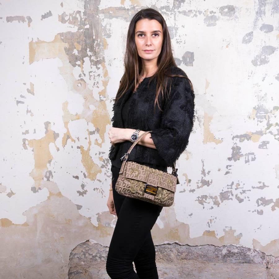 Fendi baguette bag in monogram canvas, gold thread embroidery. Ruthenium metal hardware. Snap closure. 

The interior is in brown canvas with zipper pocket. 

The FENDI buckle is set with a tiger eye stone split in several places.

Made in