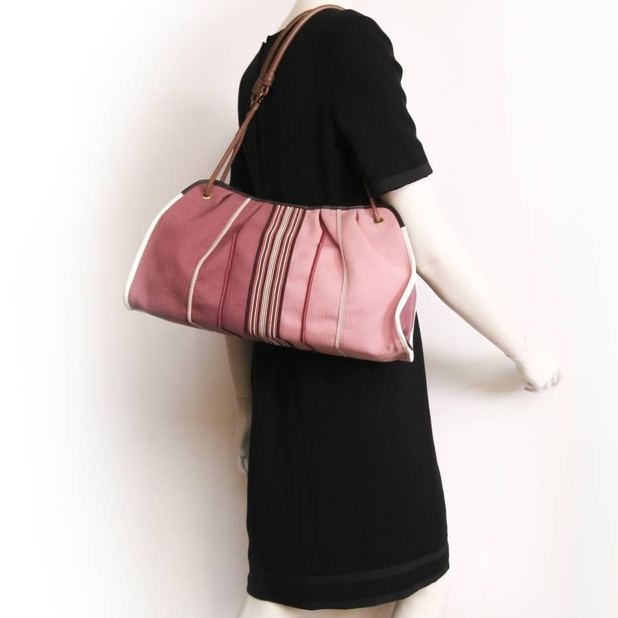 Bottega Veneta tote bag in old pink degraded canvas. Gilded metal hardware.

Worn on the shoulder with two brown leather handles. Magnetic closure. The interior is in pink-colored canvas with a smartphone pocket and a zipped pocket. 

In very good