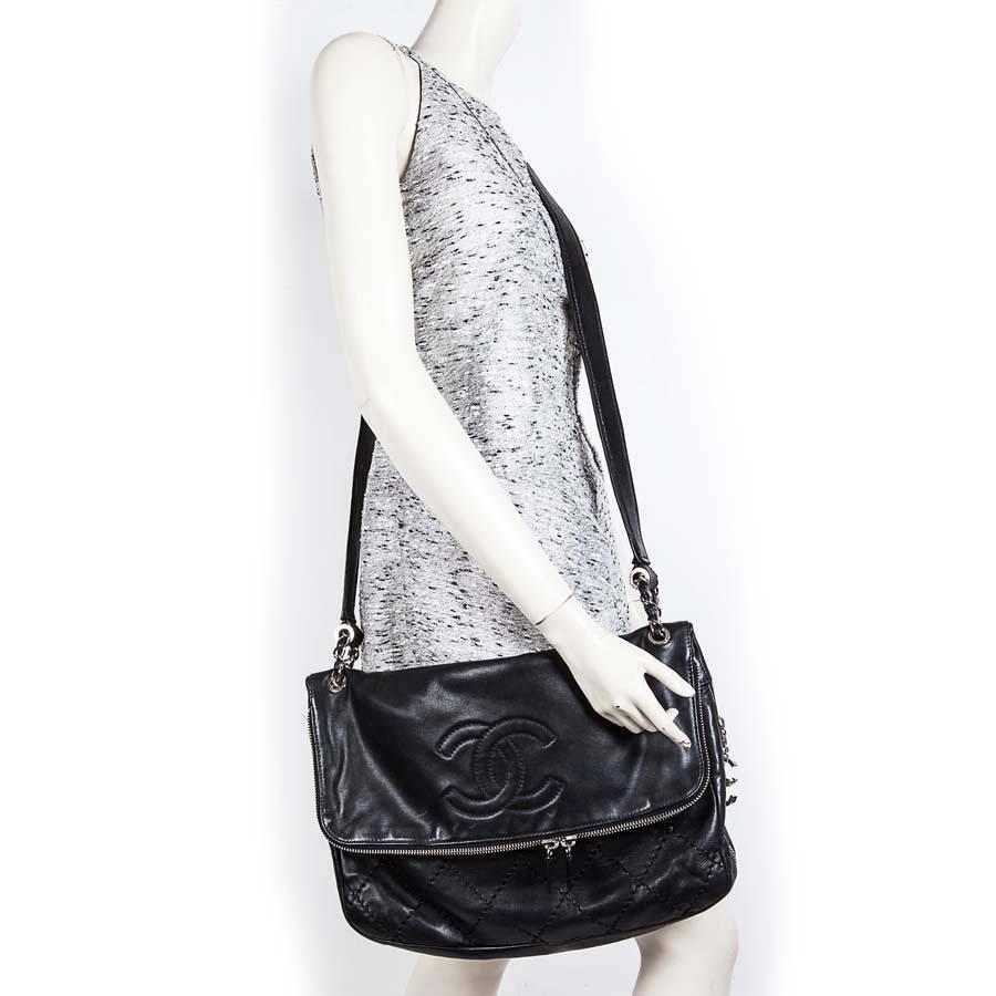 Chanel messenger bag in black quilted smooth leather, for women or men Chanel. Very wide, Worn crossover (It comes from private sales). It has a flap whose turn closes with a double zipper. 

Palladium hardware. The interior is lined in black canvas