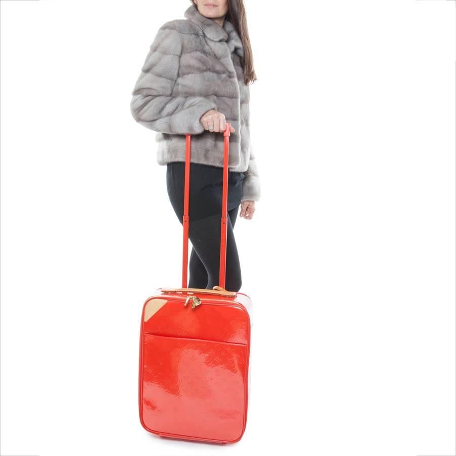Louis Vuitton Suitcase in monogram orange embossed patent leather. Gilded metal hardware. Natural cowhide finishes. Zip closure. 

Included : Address holder, padlock and keys. The interior is in canvas with ample storage space and a large zipped