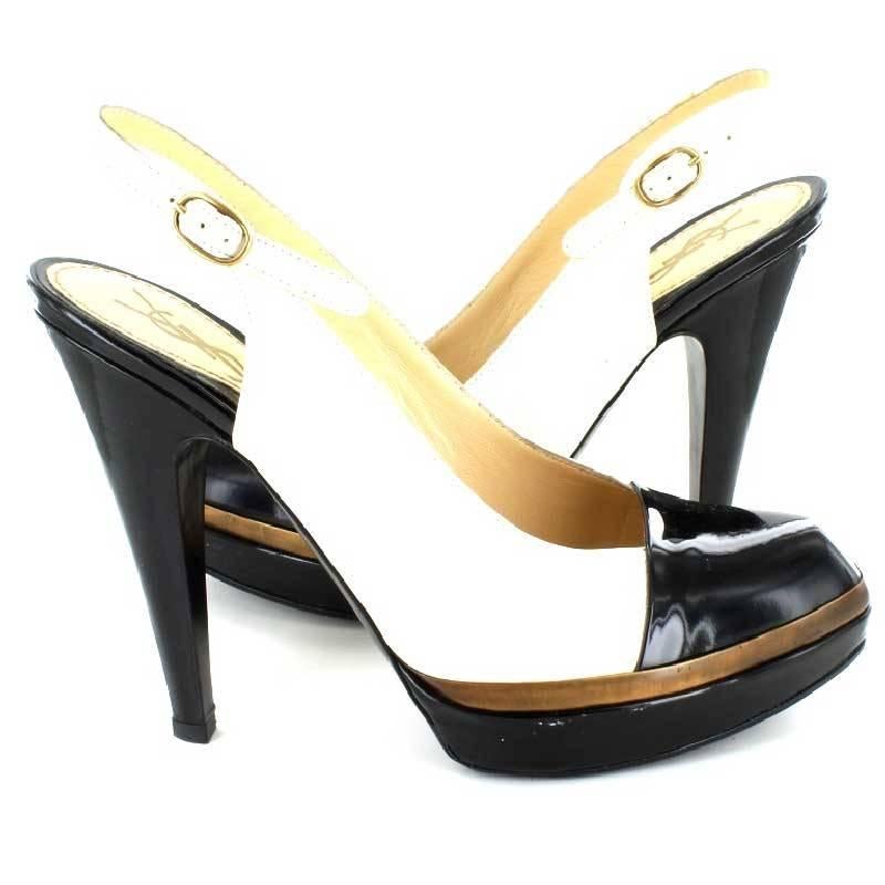 YVES SAINT LAURENT high sandals in two-tone beige and black patent leather, size 37.5FR

These shoes draw a very feminine foot. Two-tone platform black varnished and golden. The heel is covered in patent leather. Ankle strap. Leather insoles and