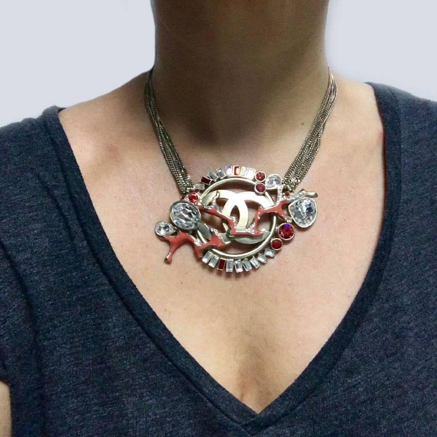 Rare piece! Choker necklace composed of 7 fine gold-plated metal chains and a monumental central jewel representing a large CC, a branch of coral, rhinestones diamonds and rubies. 

Very slight traces on the CC visible in the photos. 

This necklace