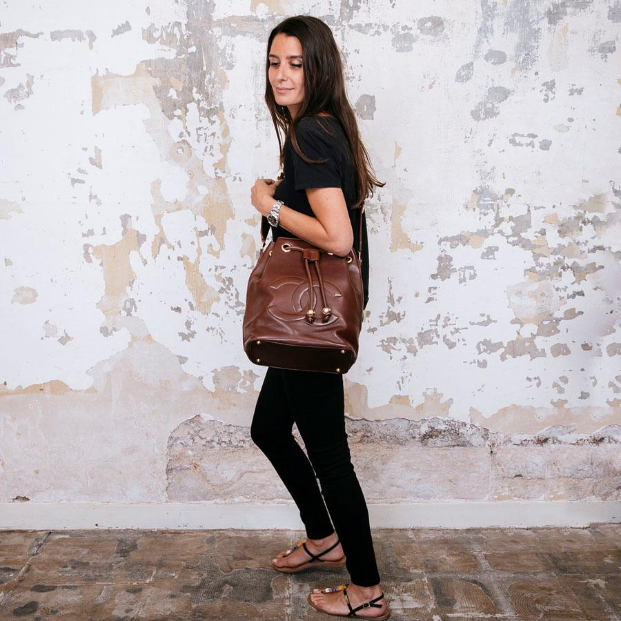 CHANEL Vintage-Eimertasche aus braunem Leder. Beschläge aus goldenem Metall. Die Innenausstattung aus bordeauxfarbenem Glattleder verfügt über eine flache Reißverschlusstasche. 

Wird auf der Schulter getragen.

Hergestellt in