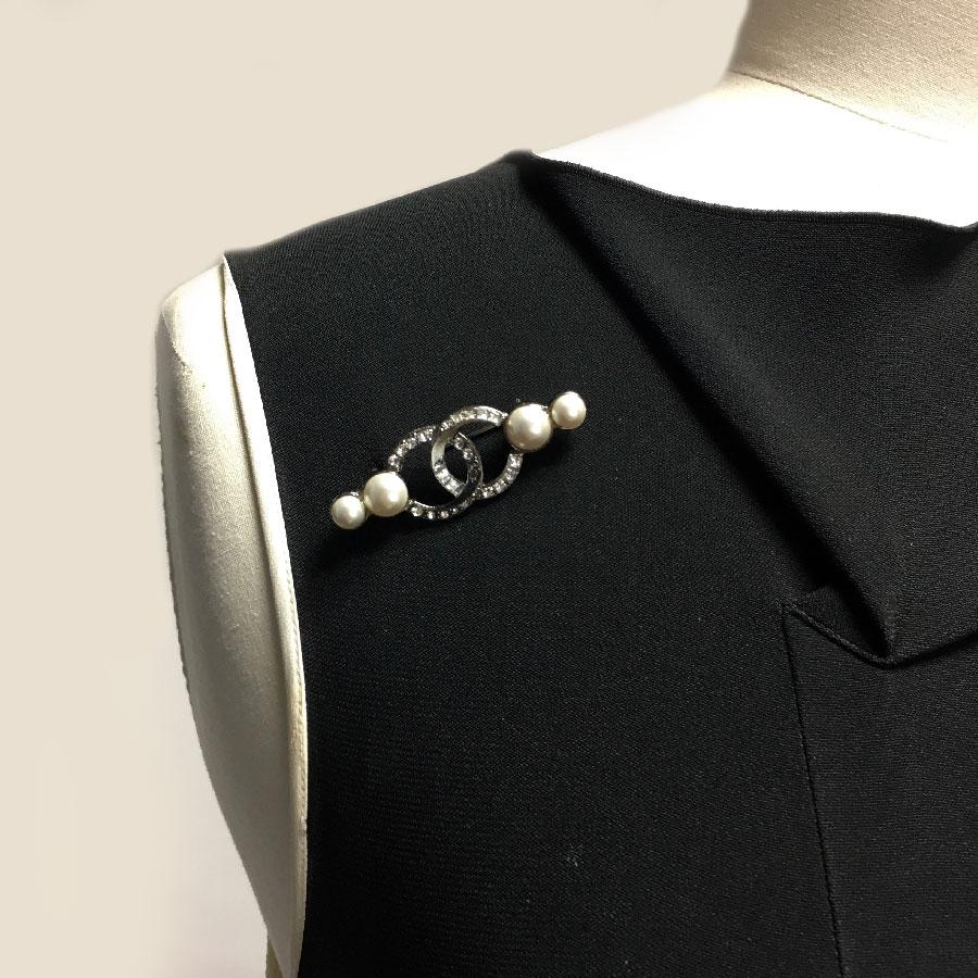 Chanel CC brooch set with rhinestones and pearls.

Immaculate condition. Made in France, 2013 collection.

Dimensions: length: 5 cm, width at the center: 1,5 cm

Will be delivered in a black box (no Chanel), Chanel ribbon and camellia.