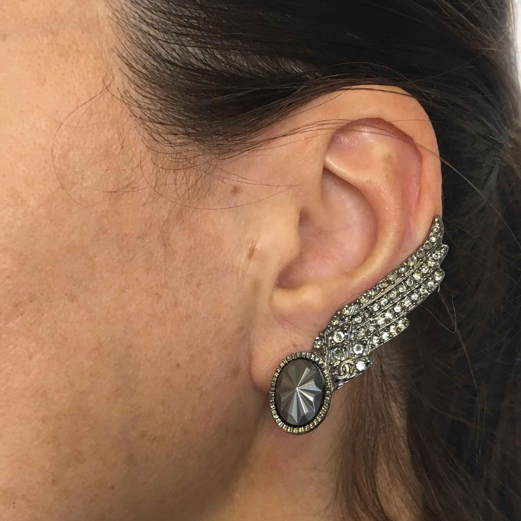Couture and fashion, wing-shaped Chanel clip-on earring, aged silver metal and rhinestones.

Clip for left ear.

Never worn. Double clip to fix the jewel on the ear. Hologram of the mark on the back of the jewel.

Spring 2016