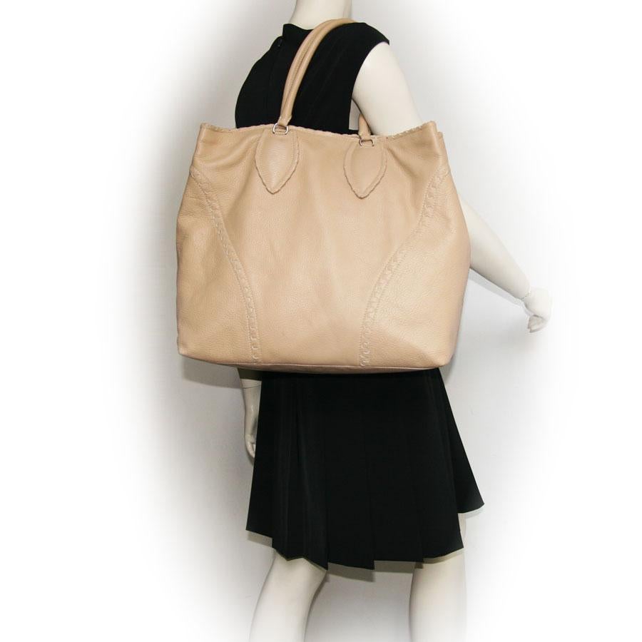 Alaïa Large tote bag in beige grained leather. 
The interior is in leather with 3 pockets including: one zipped, one that closes with a zip and the other with a pressure.
Worn by hand and arm with two handles that each measure 47 cm. 

In very good